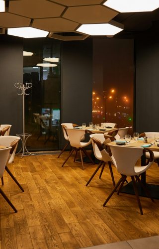 glasses near plates on wooden tables in modern restaurant